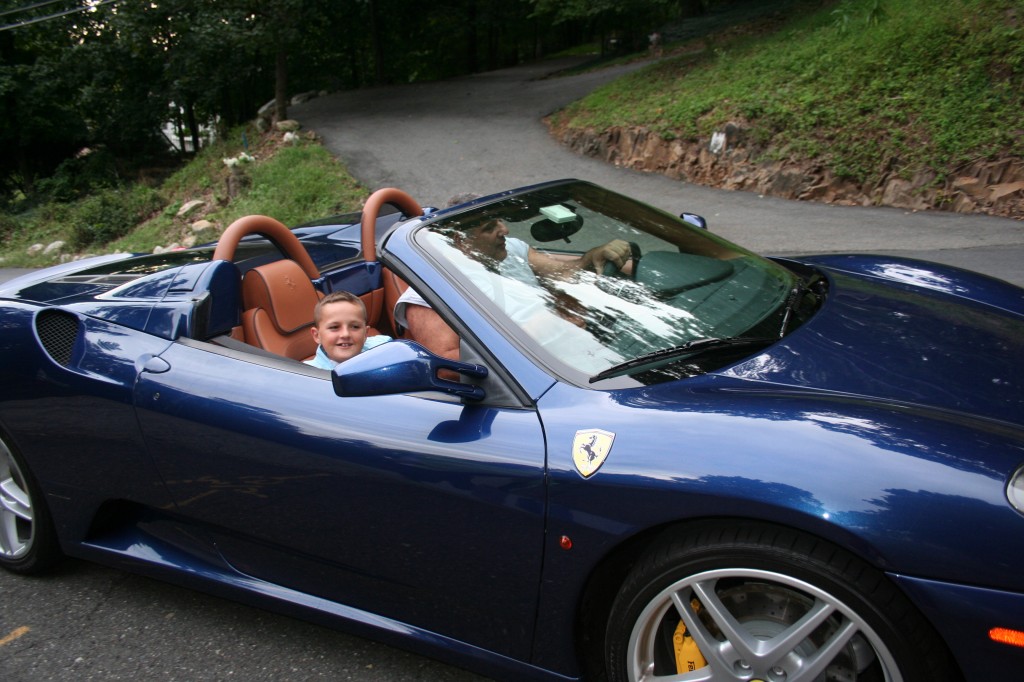 Afrim taking a ride in Rotarian Mike Rose’s Ferrari. Afrim has a passion for fine cars……